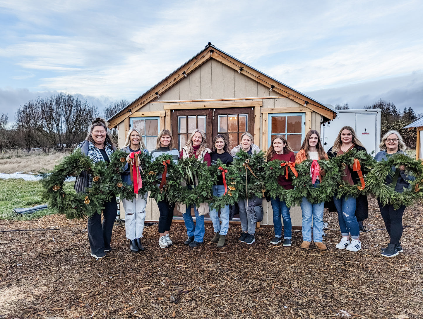 a group of women just created their holiday wreath at Breilee Flower Farm during a wreath workshop event